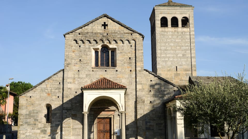 A stone church with a bell tower and a wooden door.
