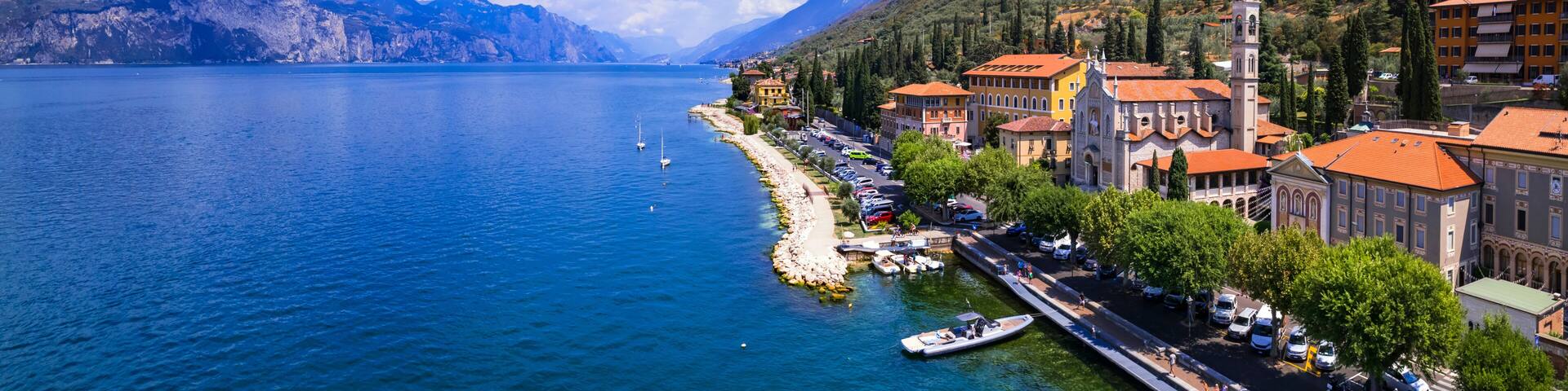 Lago di Garda Italy aerial view of Castelletto di Brenzone fishing village with colorful houses and boats lake garda travel destination scenic 4k panoramic landscape