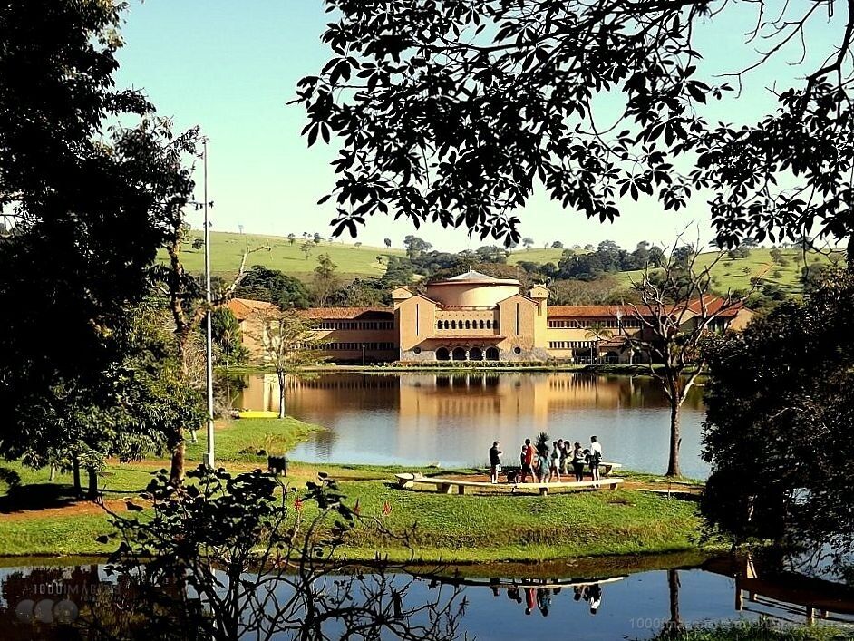 A building with a central dome, surrounded by a lake and greenery.