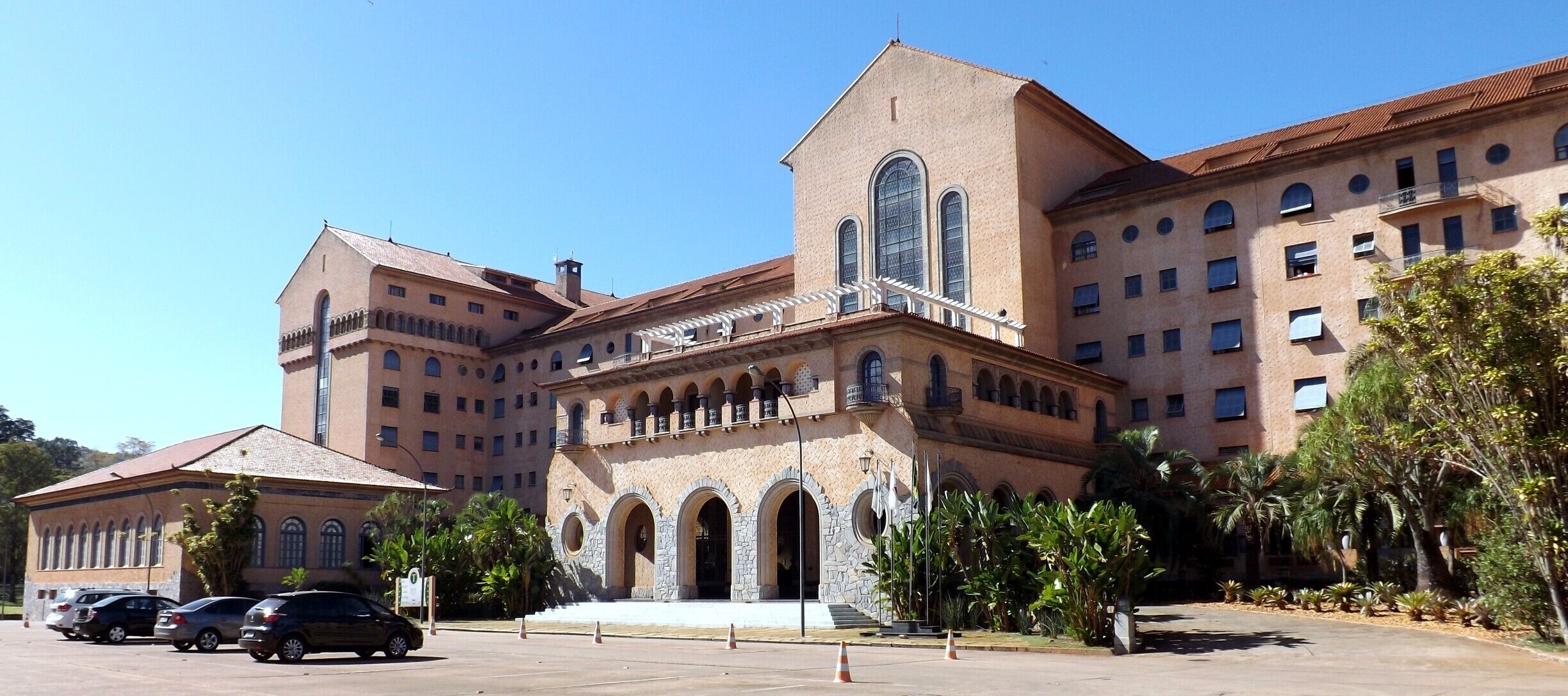 Tauá Grande Hotel e Termas de Araxá is within the Barreiro Complex, a tourist centre with thermal springs, woods and lakes. "O Grande Hotel e Termas de Araxá é um hotel da cidade de Araxá, Minas Gerais. Localizado no Parque do Barreiro, sua construção foi iniciada em 1938 e a inauguração ocorreu em 1944. O projeto do arquiteto Luiz Signorelli tem estilo arquitetônico semelhante ao encontrado nas antigas construções coloniais da América espanhola, em países como Colômbia e Venezuela. Suas paredes são revestidas com barro avermelhado, simbolizando simplicidade.Internamente, o Grande Hotel segue o estilo neo-clássico, com colunas, capitéis e arcos. O projeto inclui restaurantes, bares, um cinema."