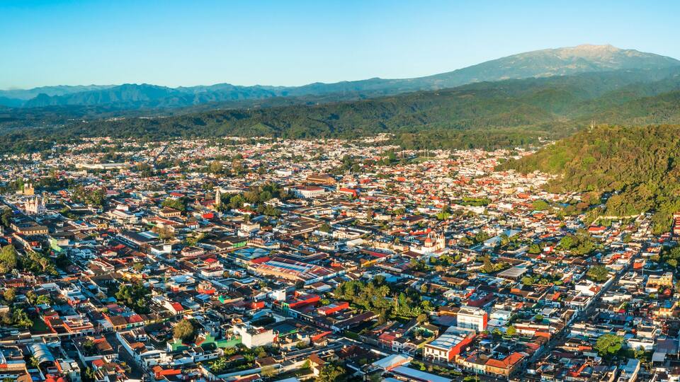 A cityscape with a mountain in the background.
