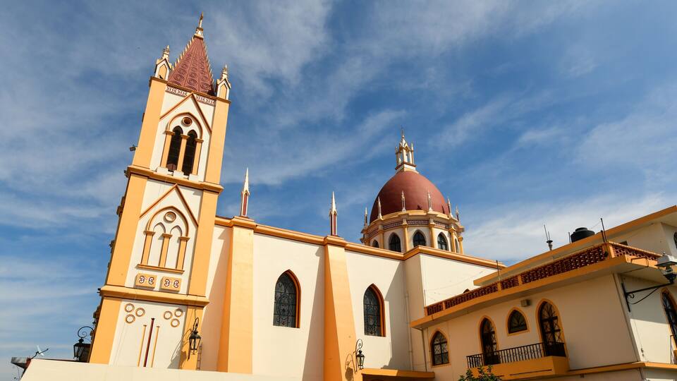 A church with a tall bell tower and a red dome.
