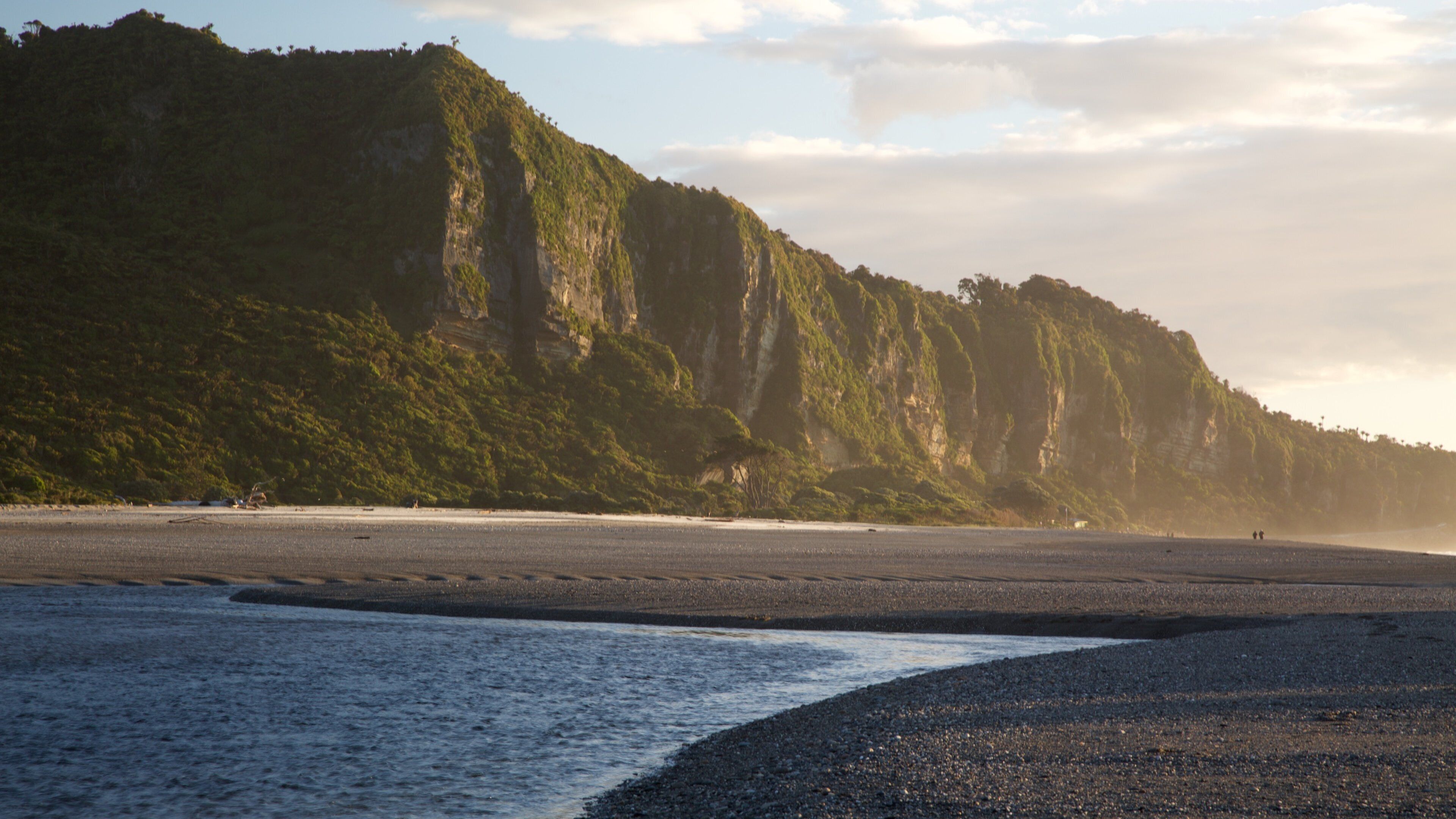 Punakaiki which includes a sandy beach, landscape views and mountains