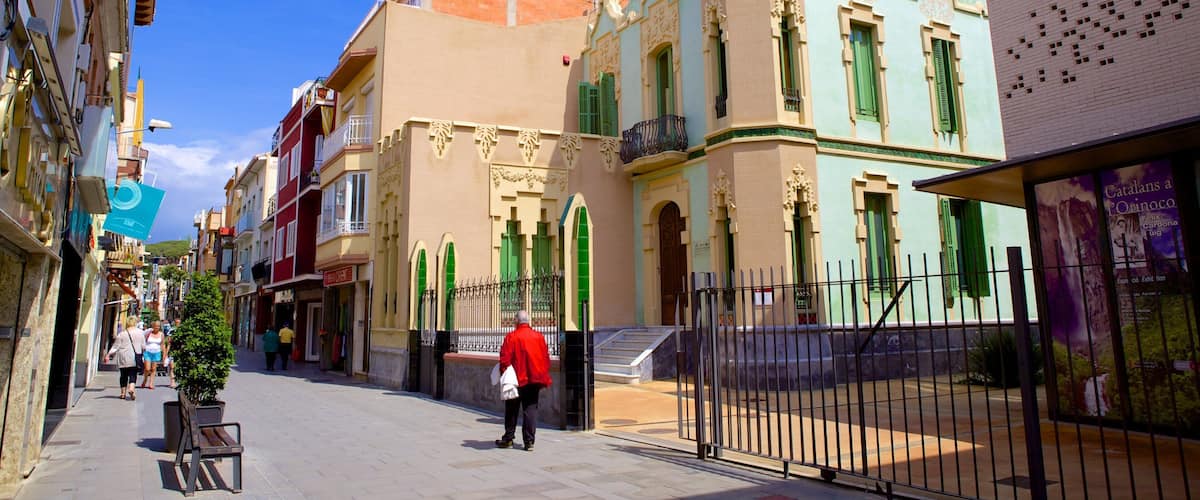 A street with historic buildings, a person in a red jacket, and a fence.