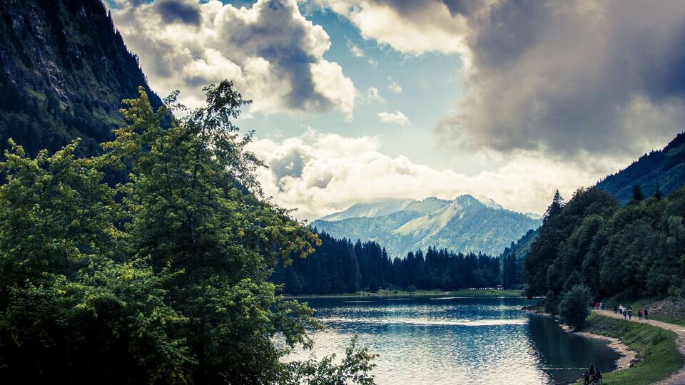 A lake surrounded by mountains and dense forests.