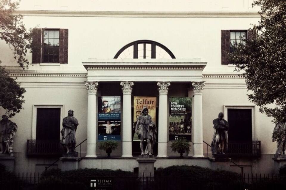 A building with classical architecture, featuring columns and statues on the facade.
