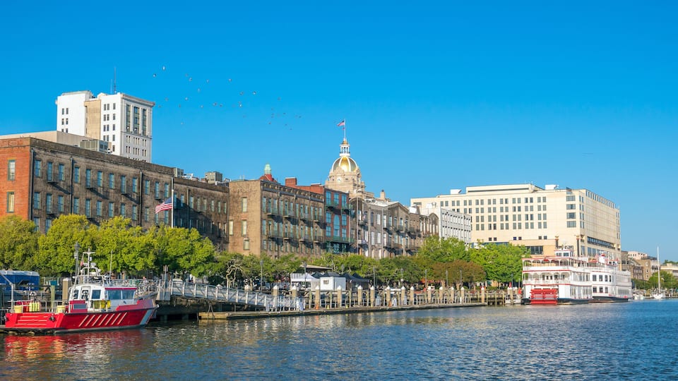 A river with boats, a bridge, and buildings along the riverbank.