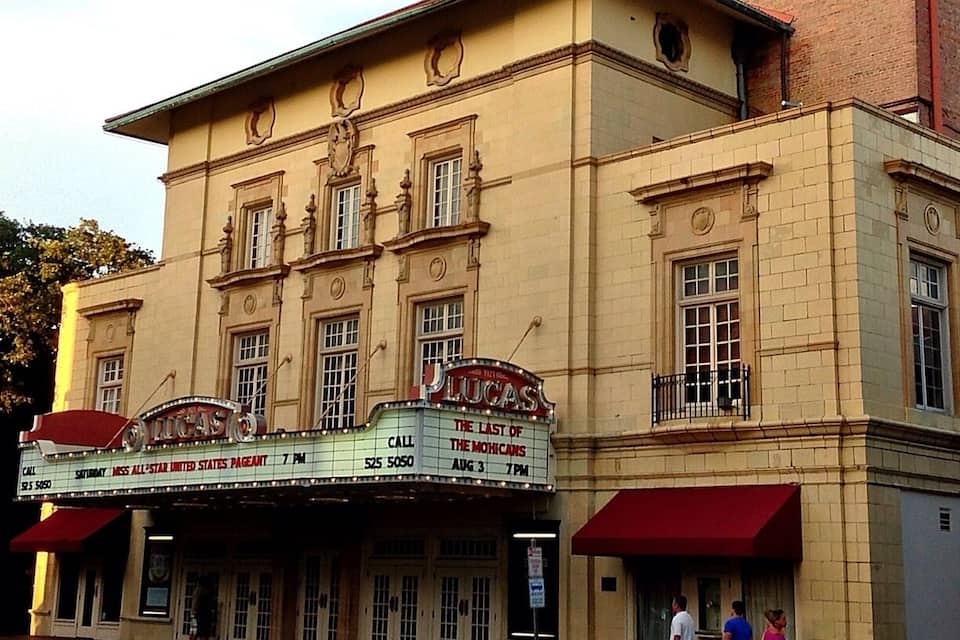 A historic theater with a marquee advertising a show.