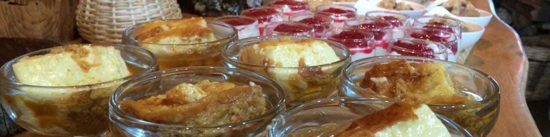 Una mesa de madera con platos de postre y una cesta de frutos secos.