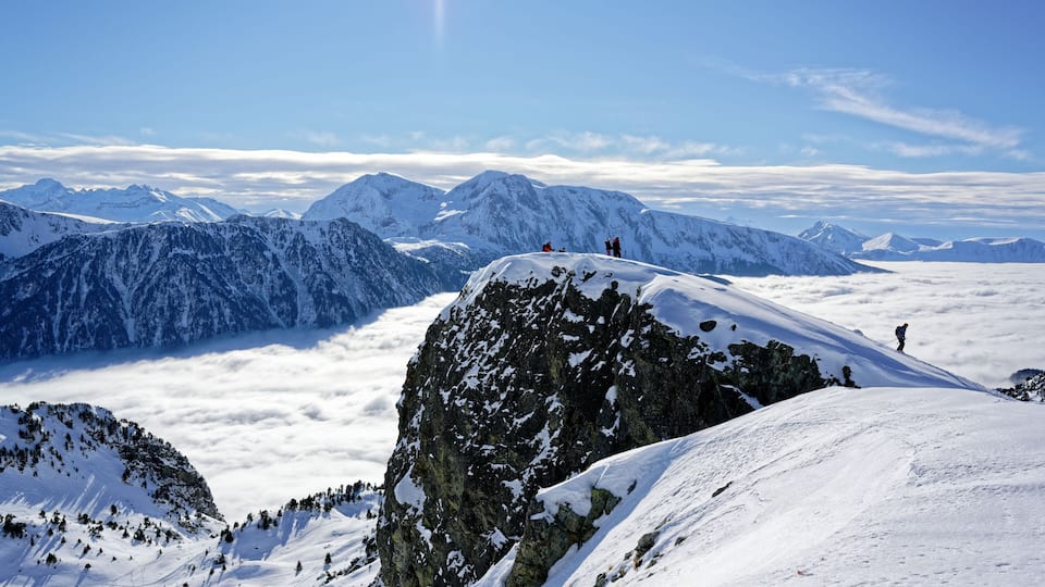 Des skieurs à Chamrousse (massif de Belledonne), avec le Taillefer en arrière-plan