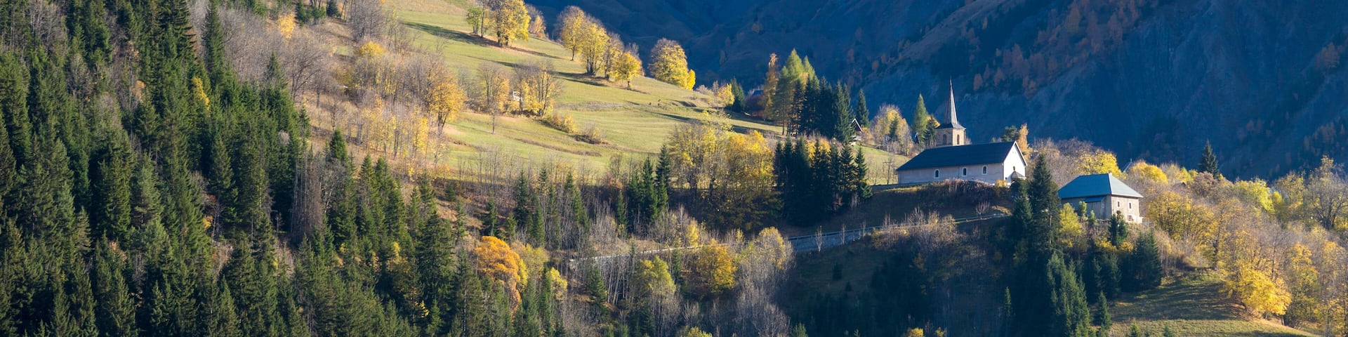 A mountainous landscape with a church and a church steeple.