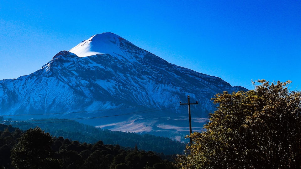 A snow-capped mountain with a clear blue sky.