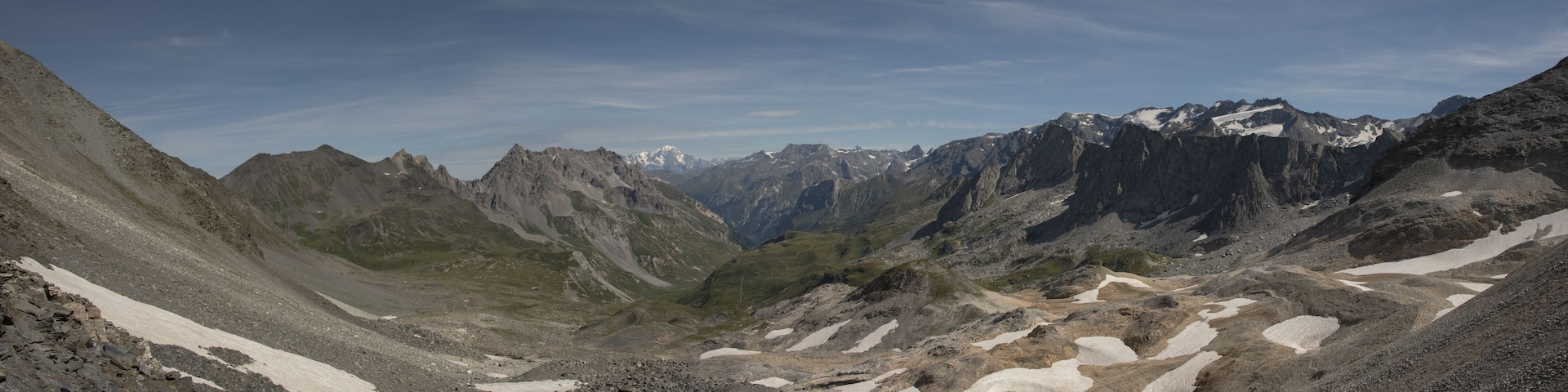 A mountainous landscape with snow patches and rocky terrain.