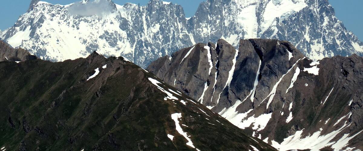 A mountain range with snow-capped peaks and a clear blue sky.