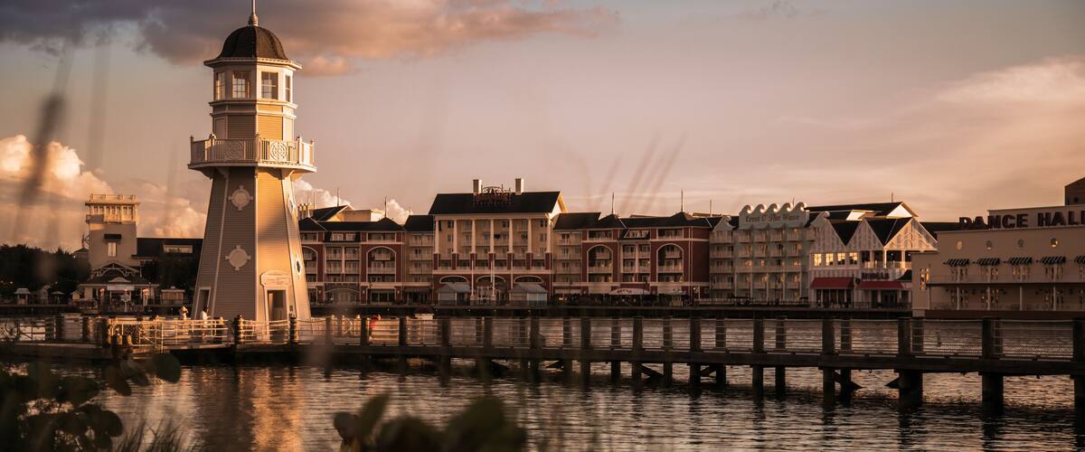 A waterfront with a lighthouse, a pier, and buildings including a hotel and a dance hall.