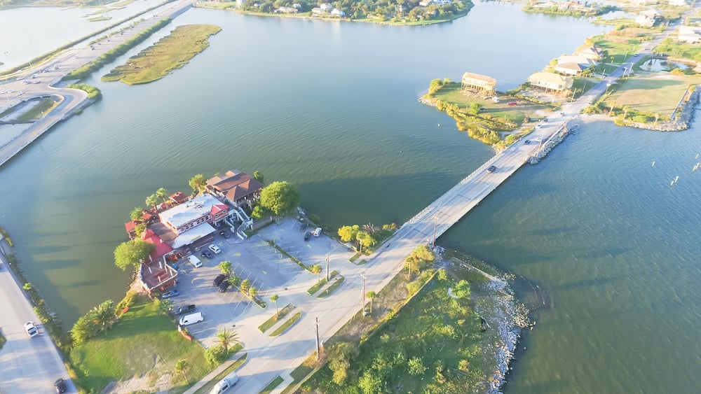 Aerial view of Seabrook city near Texas Gulf Coast and Clear Lake. Waterfront harbor town with pier. Wooden vacation house under construction. Real estate and beach travel background