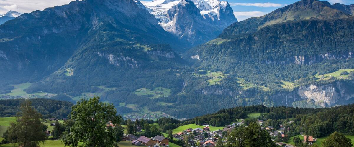 A mountain landscape with a village nestled in a valley.