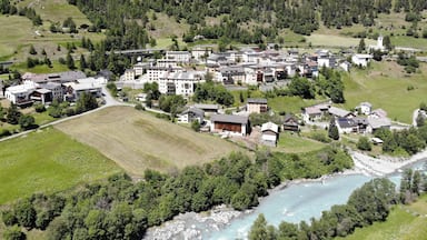 A mountainous village with a river, buildings, and a church.