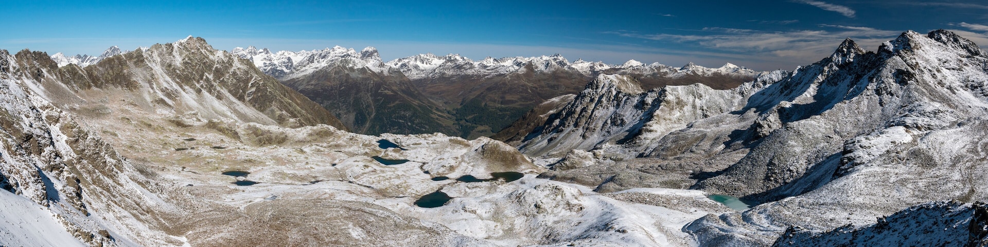 panoramic view over Macun Lakes in autumn with the first snow