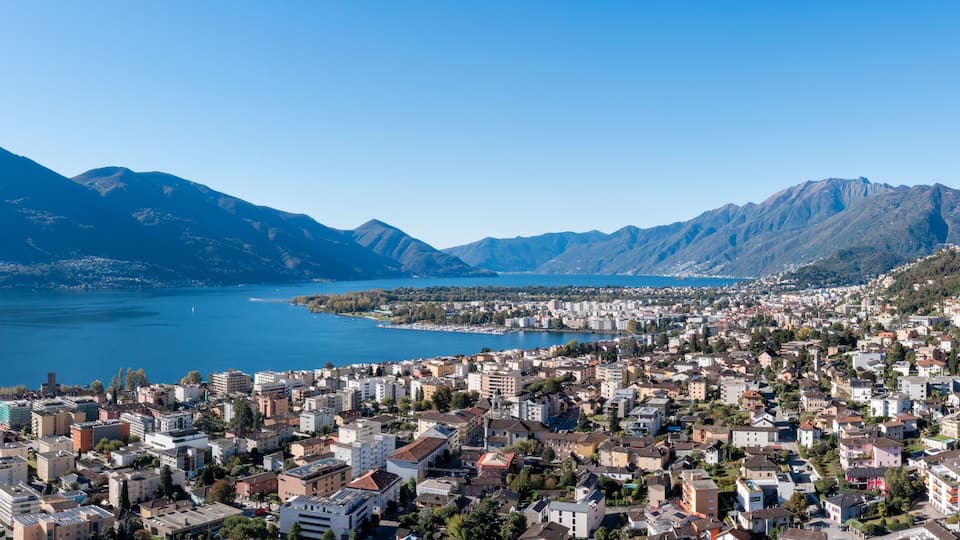A coastal city with a mountainous backdrop and a large body of water.