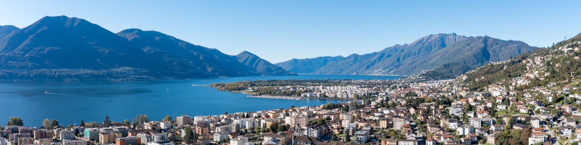 A coastal city with a mountainous backdrop and a large body of water.