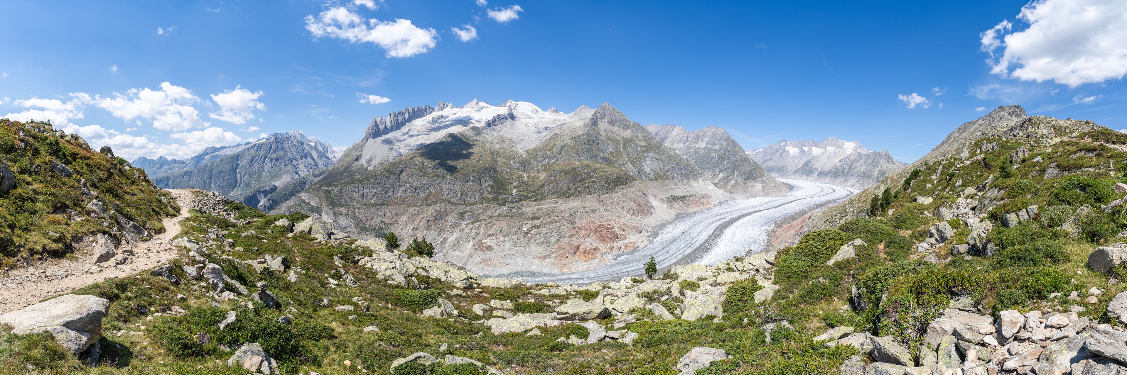 A mountainous landscape with a winding road and a glacier.