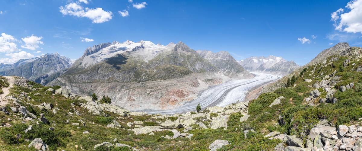 A mountainous landscape with a winding road and a glacier.