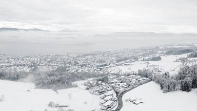 A snow-covered mountainous landscape with a town nestled at the base.