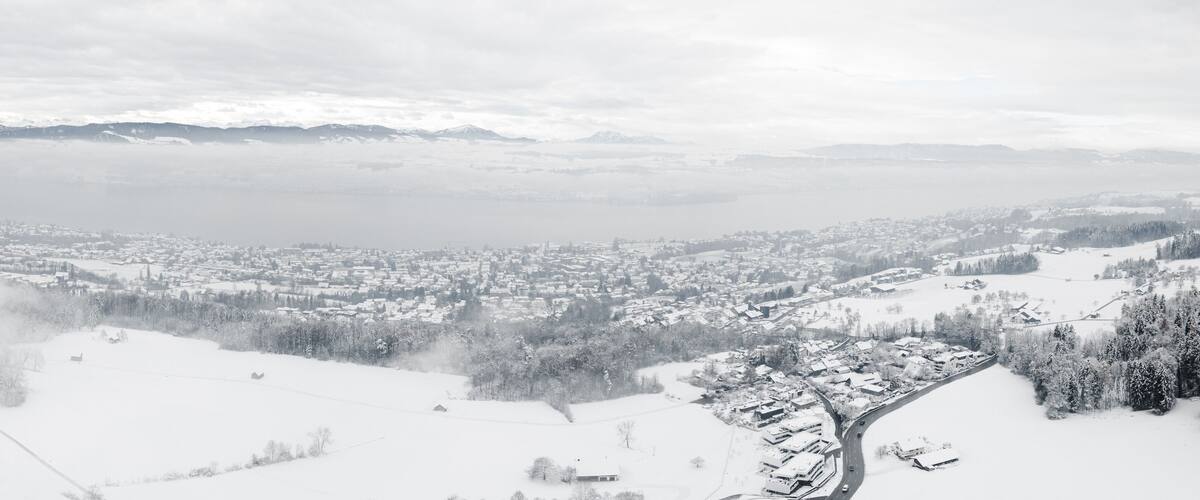 A snow-covered mountainous landscape with a town nestled at the base.