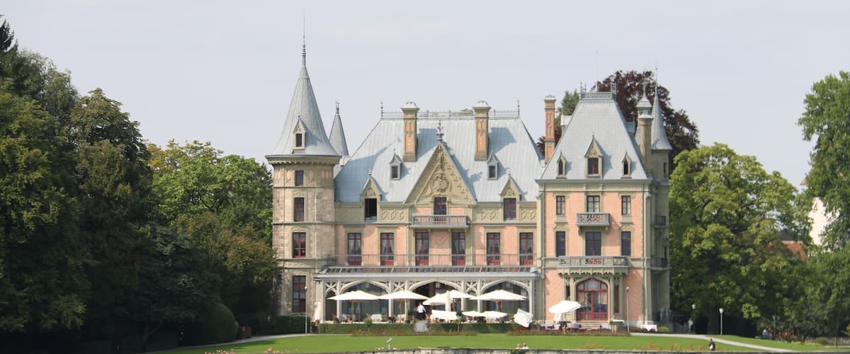 A large, historic building with multiple towers and a waterfront.