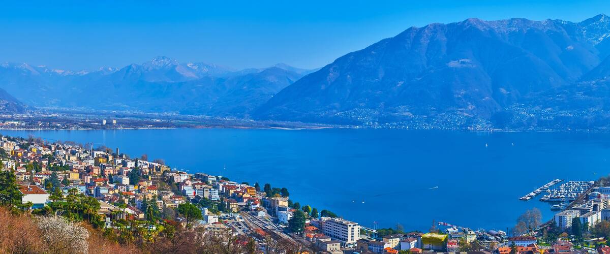 A coastal city with a mountainous backdrop and a marina.