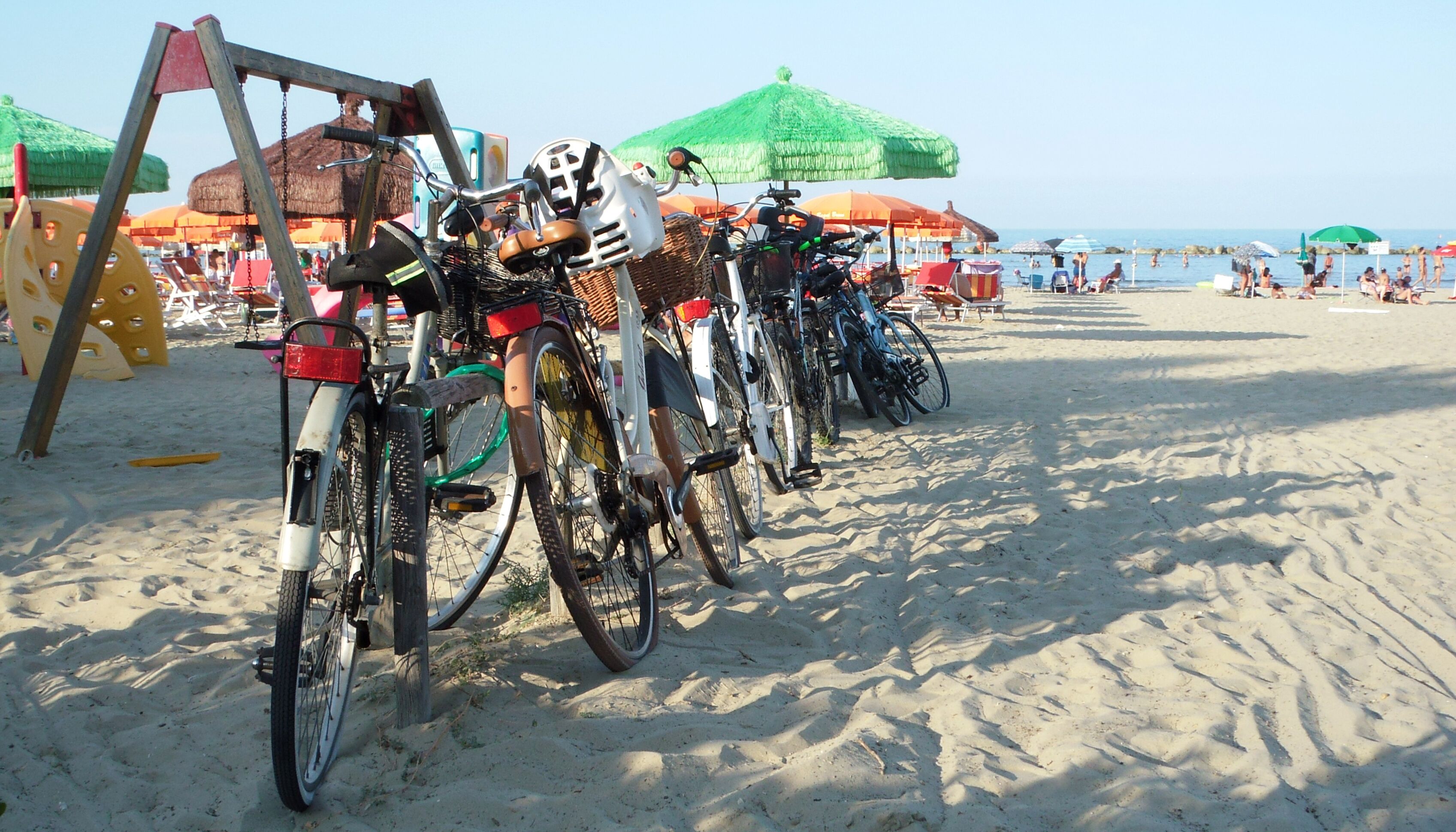 vecchie e nuove biciclette parcheggiate sulla spiaggia,in una calda giornata estiva