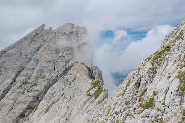 A rugged mountain peak with steep, rocky slopes and patches of greenery.
