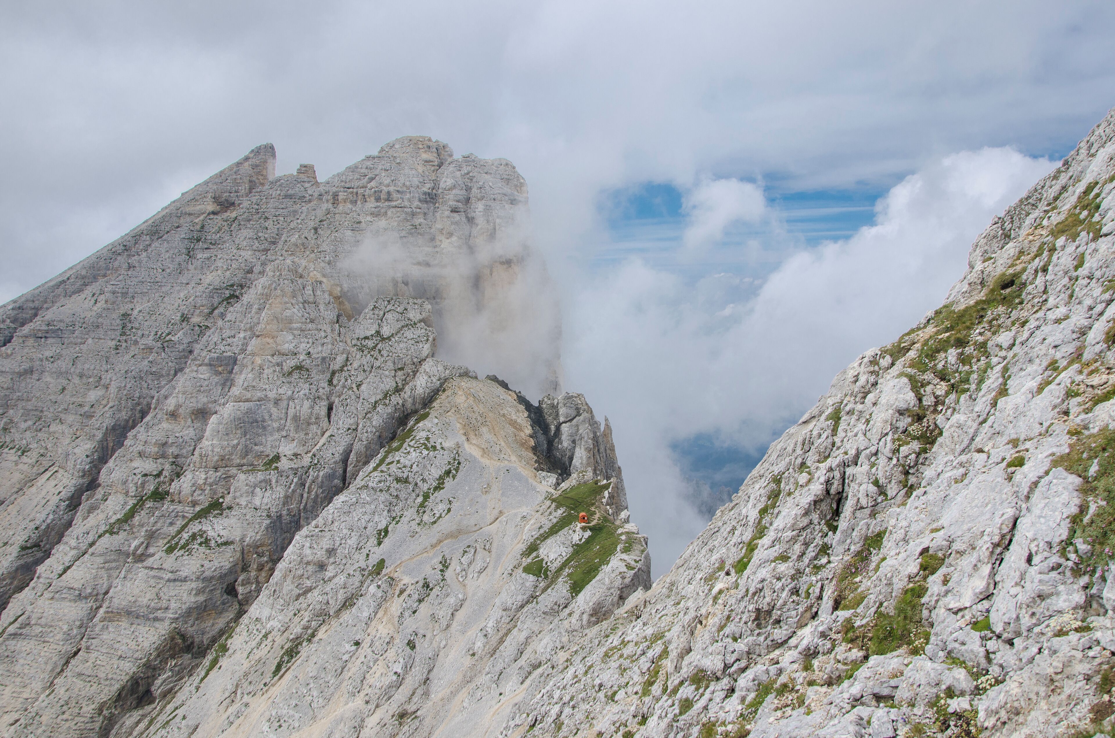 A rugged mountain peak with steep, rocky slopes and patches of greenery.