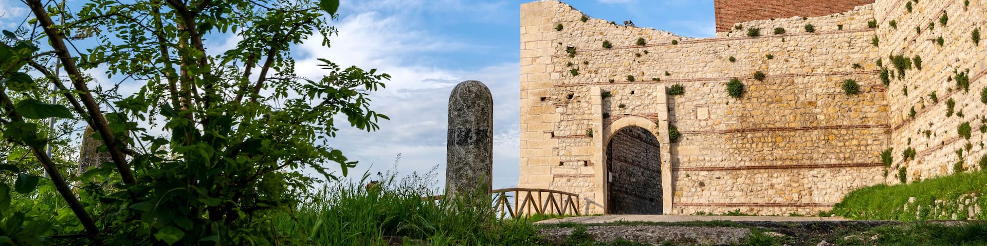 Stone entrance with the tower of Romeo and Juliet's castle in the province of Vicenza in Montecchio Maggiore.Blue sky clouds at Romeo's Bellaguardia Castle Vicenza Veneto Italy Europe.