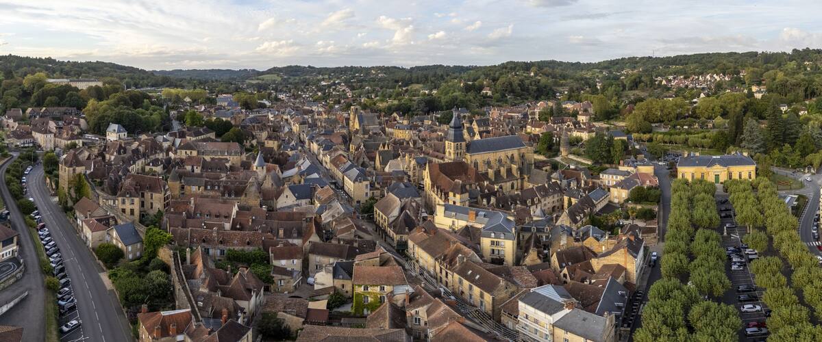 A historic town with dense architecture, a prominent church, and a river running through the center.