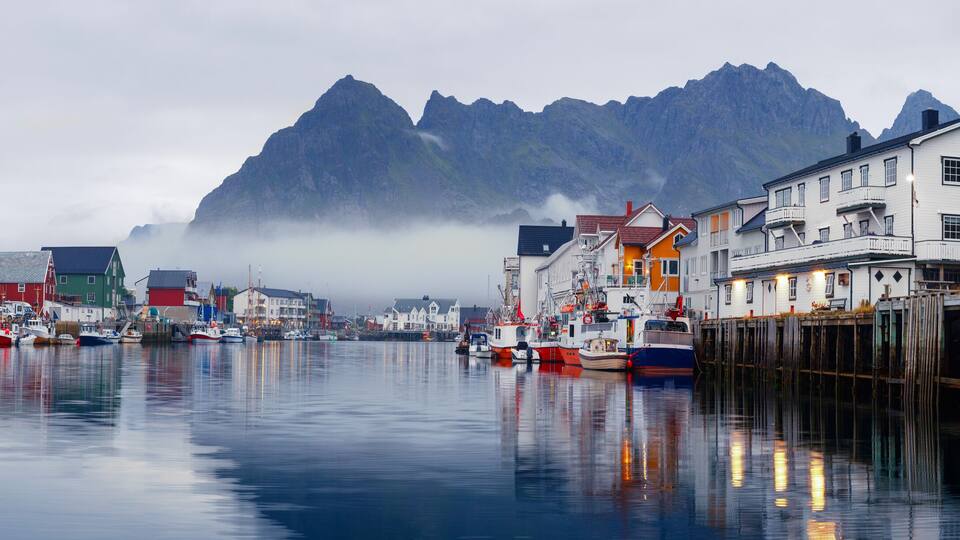 Scenic view of the waterfront harbor in Henningsvaer in summer. Henningsvaer is a fishing village and tourist town located on Austvagoya in the Lofoten Islands. Norway.