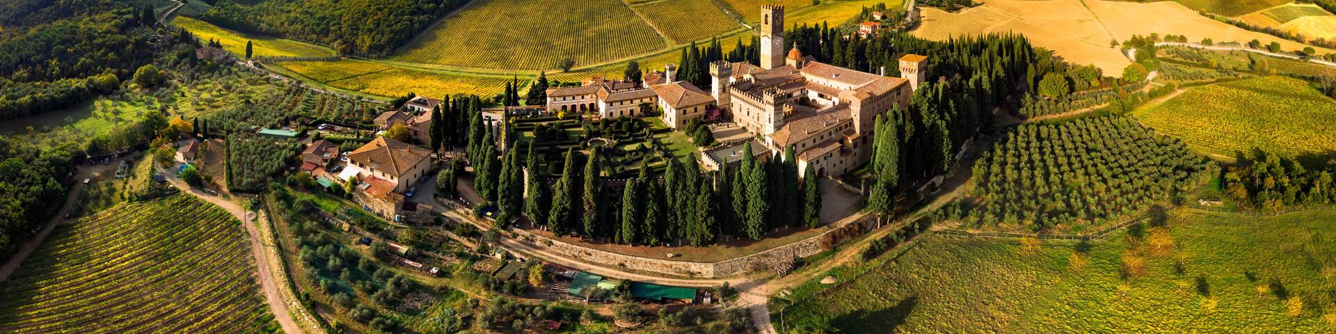 Badia a Passignano Italy aerial panorama in 12k high resolution. Chianti Classico wine region Tuscany. Medieval abbey and village surrounded by vineyards and cypresses. World Print quality scenery