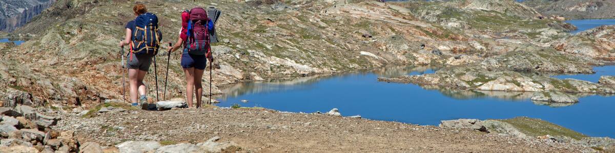OZ-EN-OISANS, FRANCE, August 8, 2023 : Hikers walk on paths over the lakes of Grandes Rousses mountain range