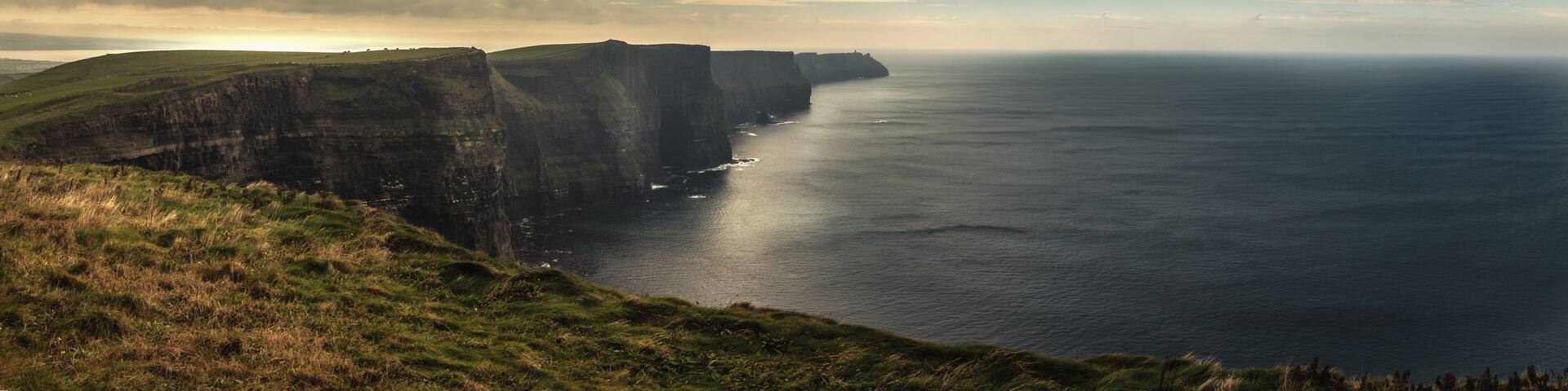 A coastal cliff landscape with a view of the sea.