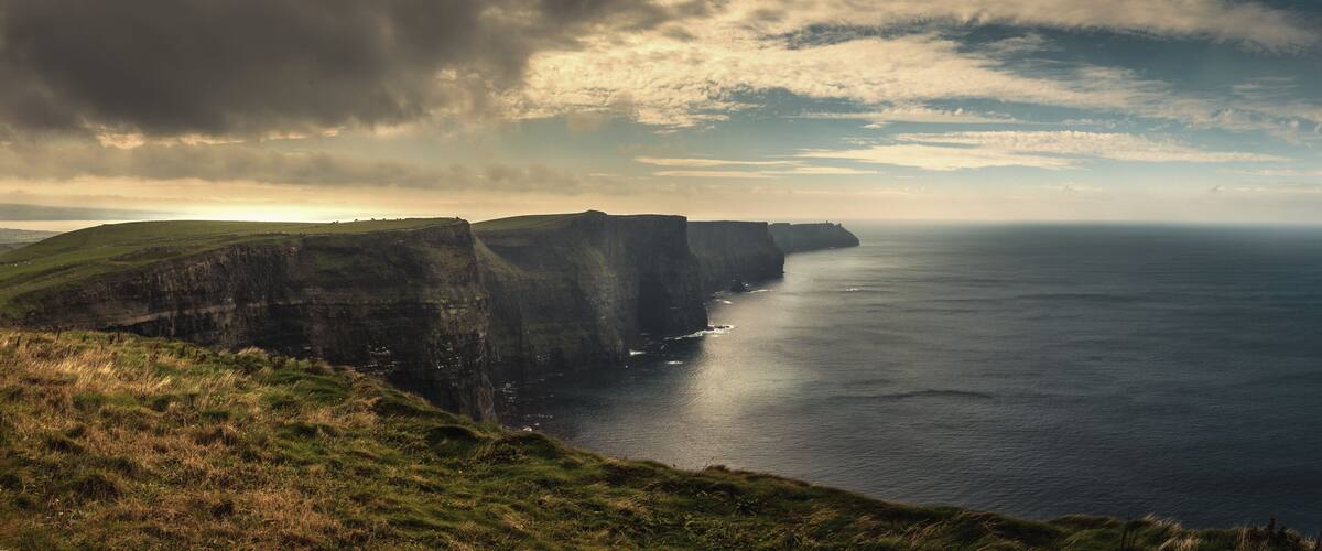 A coastal cliff landscape with a view of the sea.