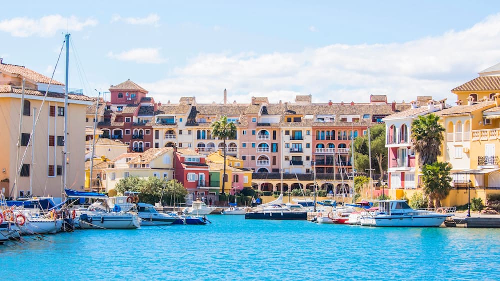 Un port de plaisance avec des bâtiments aux couleurs vives et des bateaux amarrés.