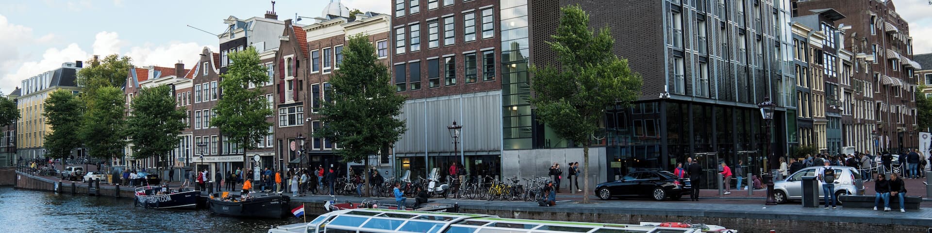 A canal with a boat named 'Jorden Krabbe' and historic buildings along the riverbank.