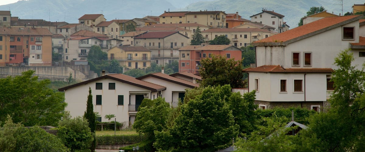 A town with buildings and mountains in the background.