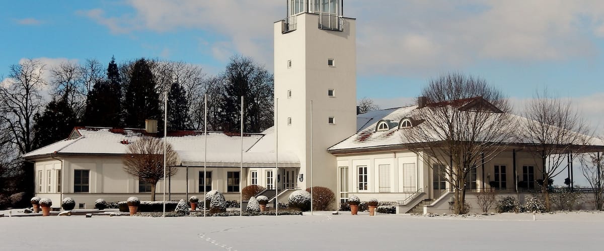 A large white building with a tall tower and a smaller attached building.