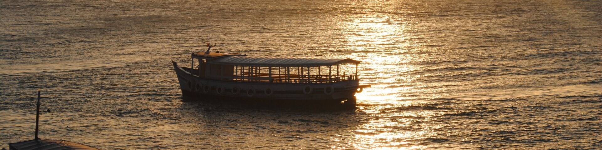 A boat on calm water during sunset.