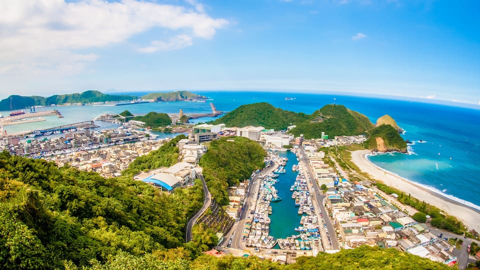 A coastal town with a marina, a bridge, and a beach.