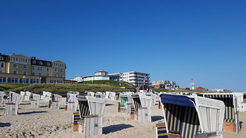 Beach chairs and a building in the background.