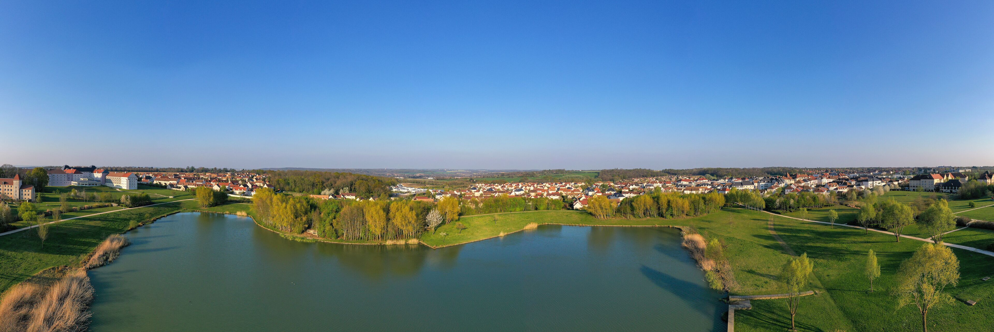 A river meandering through a town with surrounding greenery and buildings.
