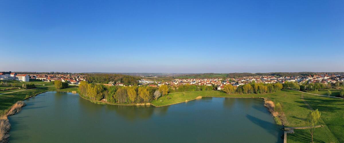 A river meandering through a town with surrounding greenery and buildings.
